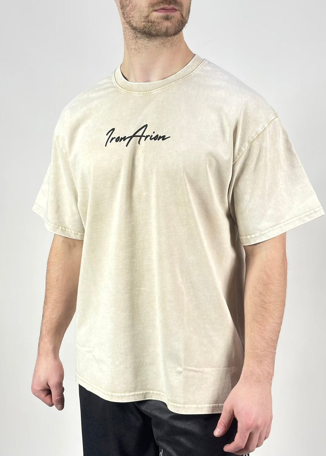 Man wearing a beige t-shirt with 'Iron Aries' logo on a plain background